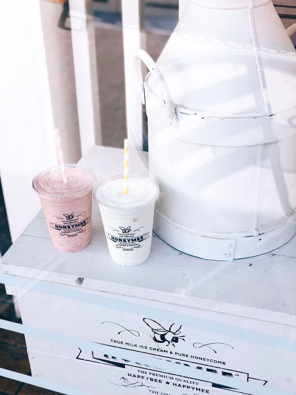 Strawberry and vanilla milkshakes on a white milk can